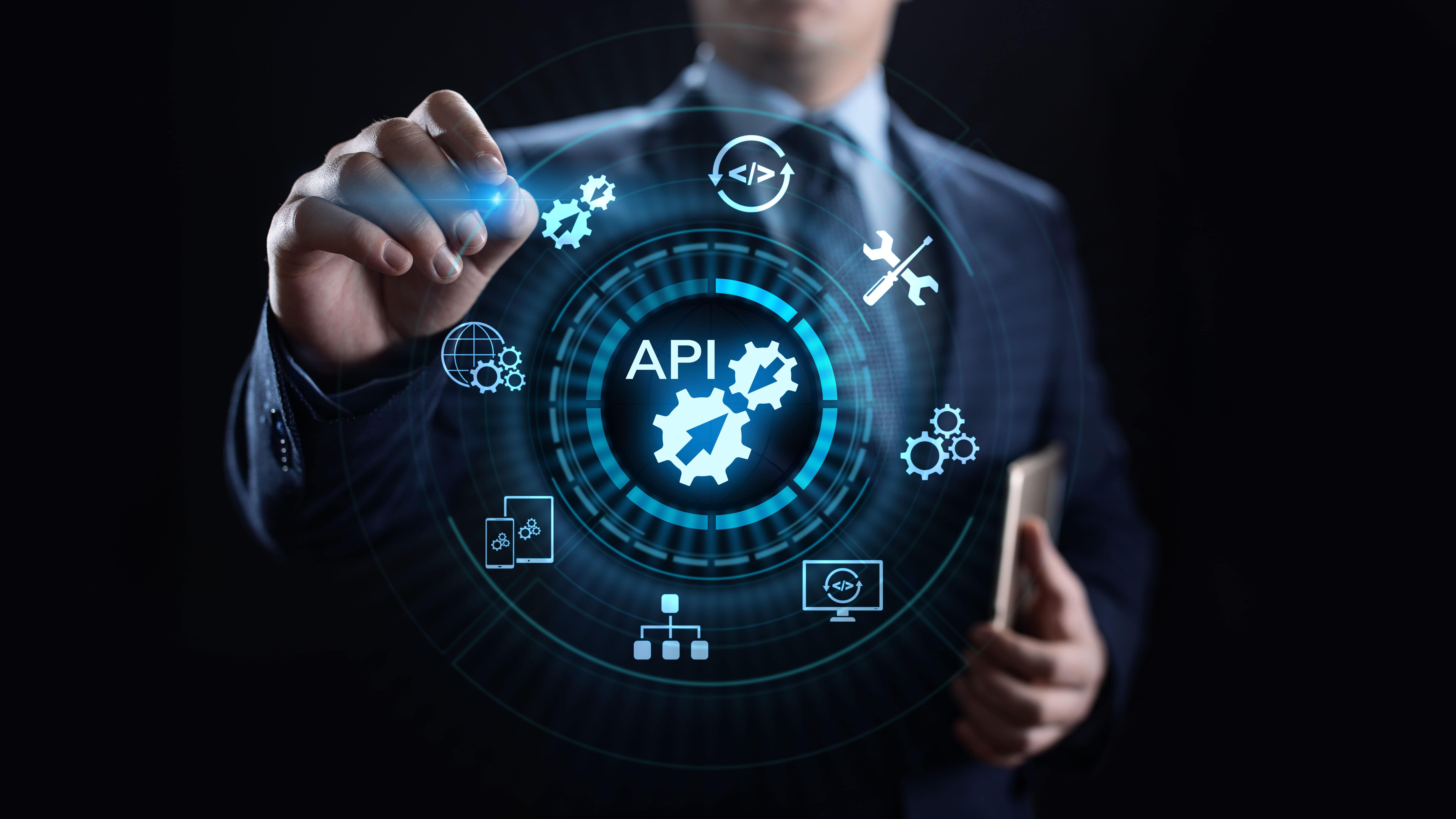 business man pointing to icons showing APIs and microservices